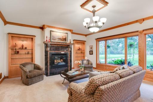 Another view of the living room featuring a cozy gas fireplace and built-in shelving.