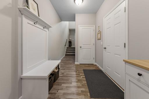Landing area of entry to lower level. Plenty of storage and convenient bench.