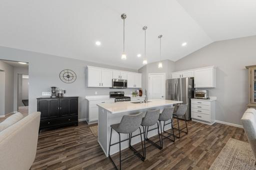 Another angle of kitchen with LVP flooring, quartz countertops and stainless steel appliances.