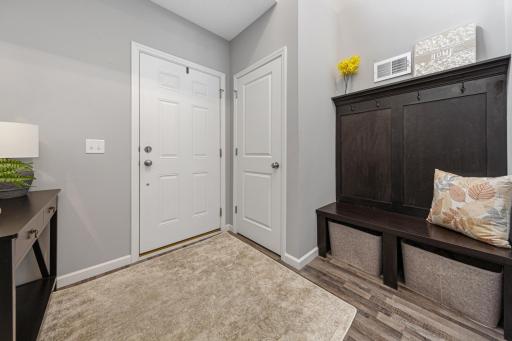 Spacious entry way with convenient bench for storage and coats.