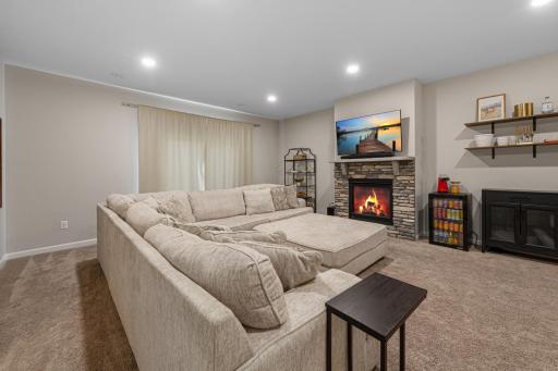 Large lower level living area with beautiful stone fireplace.