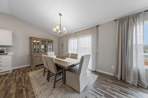 Dining area with LVP flooring, beautiful lighting and elegant decor.