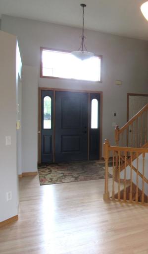 Spacious entry with transom window above for natural light, updated front door and side windows (2022) and coat closet.