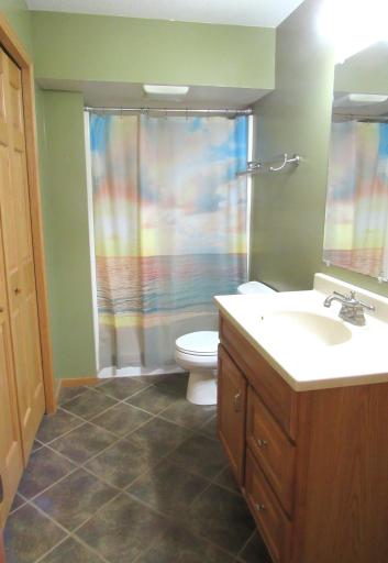 Lower level bath with a ceramic tiled floor with in-floor heat, huge double linen closet, roomy step in shower and nice vanity with composite counter top.