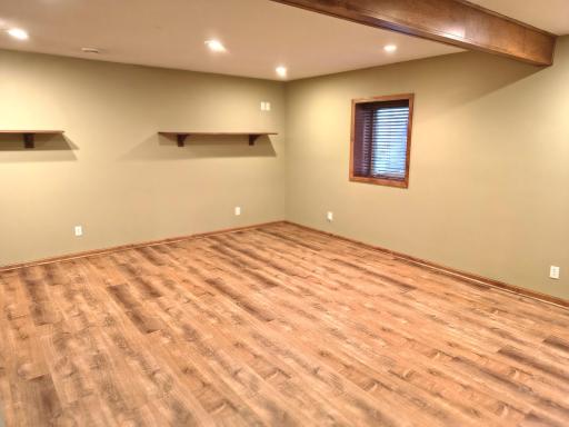 4th level rec room with new plank flooring, recessed lighting, shelves and an egress window with a security latch.