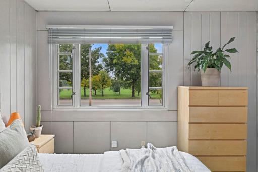 A large window fills the bedroom with natural light and neighborhood views.
