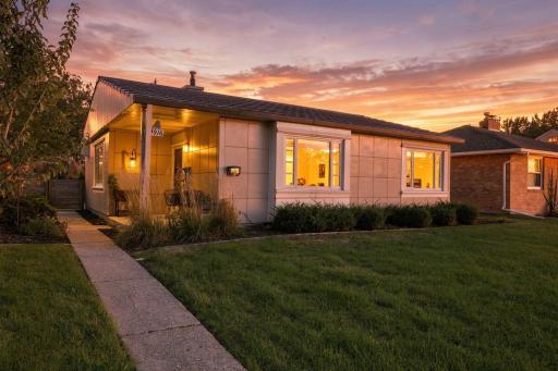 A rare Lustron home, finished in its original porcelain-enameled steel and glowing at sunset.