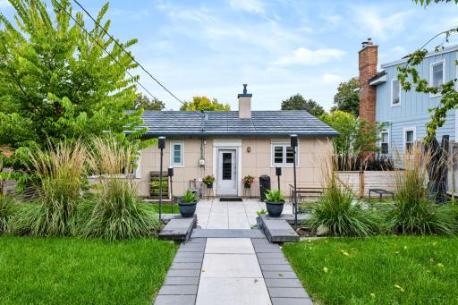 A landscaped path connects the home, lawn, patio, and garage.