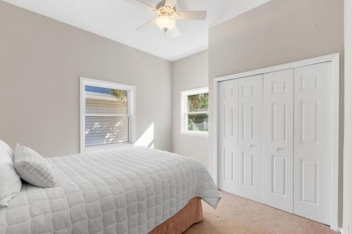 Generous primary suite offering abundant natural light, hardwood flooring, and tranquil backyard exposure.