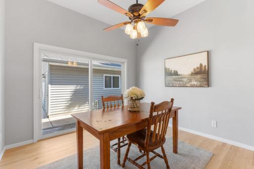 Dedicated dining space adjacent to the kitchen with high ceilings and backyard views.