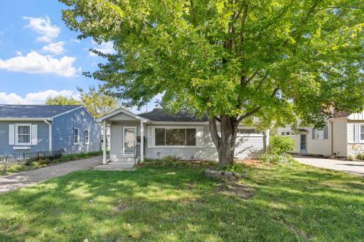 Welcoming front elevation featuring mature shade trees, low-maintenance siding, and inviting curb appeal.