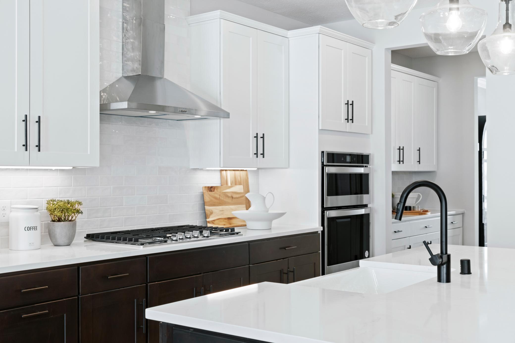 Gourmet kitchen with tile backsplash and double ovens
