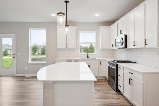 Curved center island with quartz countertops