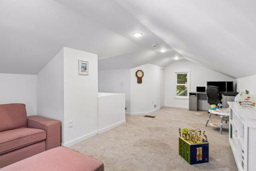 Expansive upper-level bedroom offers plenty of room for multiple uses, currently arranged as a sitting/play area and home office.