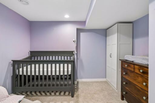 Lower-level fourth bedroom with an egress window, currently used as a nursery.