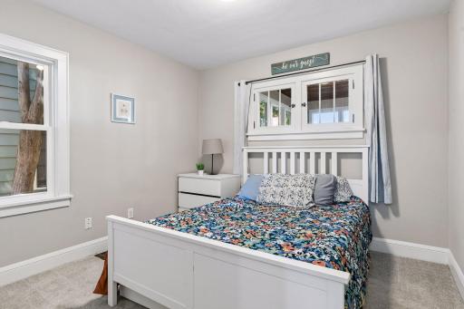 Main-level bedroom with two windows, neutral finishes, and convenient access to the full bathroom.