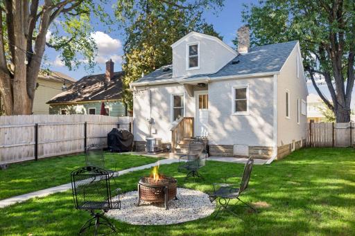 Fully fenced backyard with green space, fire pit area, and new detached two-car garage built in 2024.