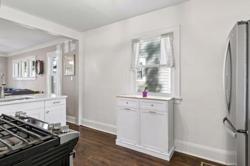 Bright kitchen offers additional cabinetry and storage, stainless-steel appliances, hardwood floors and easy connection to the dining and living areas.