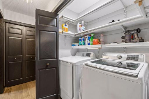 The conveniently located laundry area includes adjustable shelving for supplies and helps support easy one-level living.