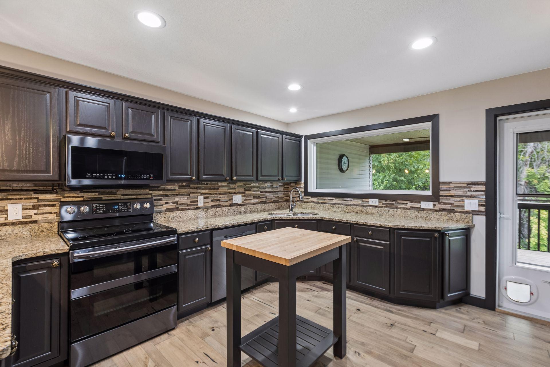 The kitchen is designed for efficiency, with plenty of counter space, a central butcher-block prep island, and a double oven.