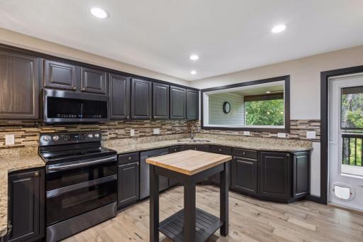 The kitchen is designed for efficiency, with plenty of counter space, a central butcher-block prep island, and a double oven.
