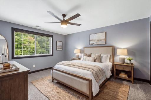 The third bedroom on the lower level is spacious and offers a generous closet with a custom organizer and built-in wall safe. The large window offers plenty of natural light and beautiful views of the backyard and treeline.