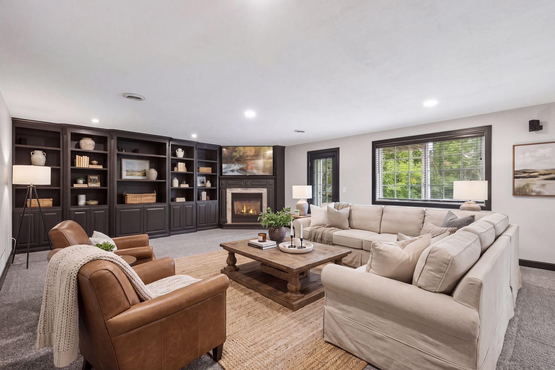A large window and walkout access bring natural light into the family room while connecting the space to the outdoors, the covered patio, and the wooded backdrop.