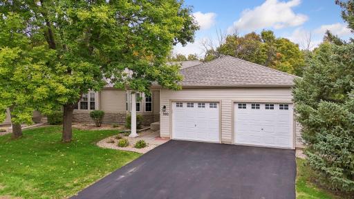 The mature trees and well-maintained lawn frame the welcoming front entrance of this thoughtfully customized one-level townhome.