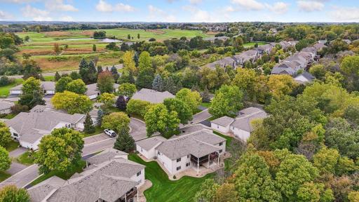 An elevated view highlights the homeâs attractive Chaska setting, surrounded by mature trees, expansive green space, and nearby recreational amenities.