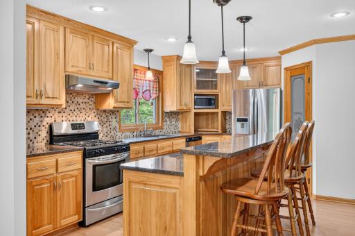 A warm, functional kitchen with abundant cabinetry and multiple work surfaces.