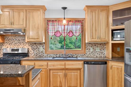Rich wood cabinetry pairs with hard-surface countertops and stainless steel appliances.
