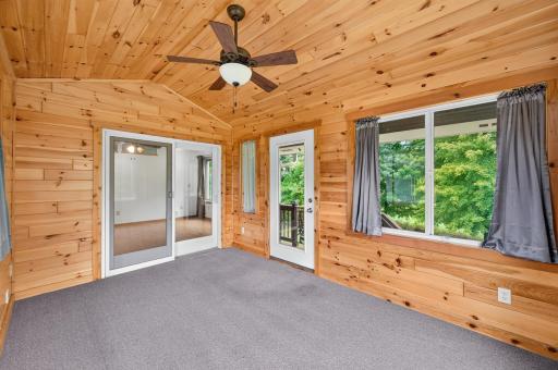 Windows on multiple sides fill the porch with natural light and views of the property.