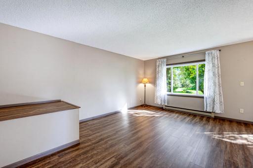 The living room features a large window with a view of the front yard.