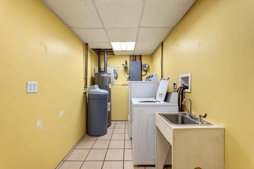 Laundry room. An owned water softener and an electric hot water heater are included.