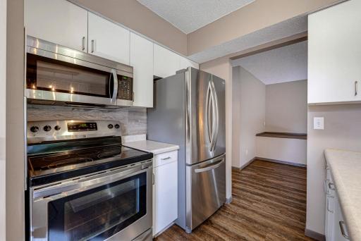 The kitchen features a suite of stainless steel appliances.