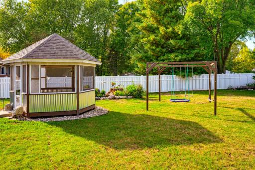 The beautifully landscaped yard includes a gazebo, a concrete patio, and stunning flower gardens. The swing set will stay.