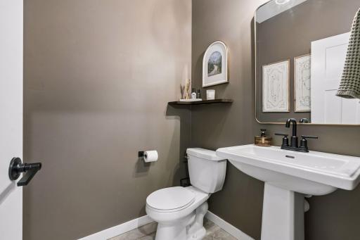 Convenient 1/2 bath on the main level with upgraded light fixture and custom shelving.