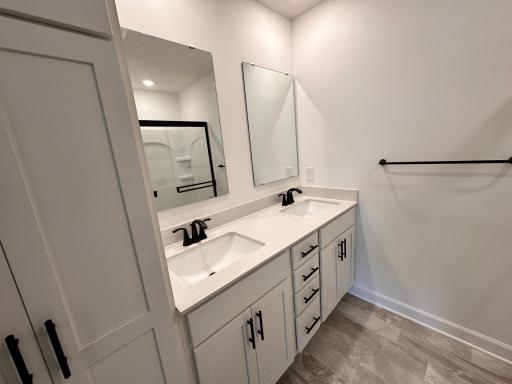 Primary Bath with Double vanity, storage cabinet and glass door shower
