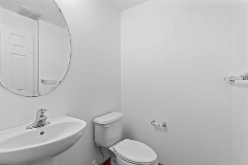 The main-level 1/2 bathroom located near the entrance to the attached 2-car garage.