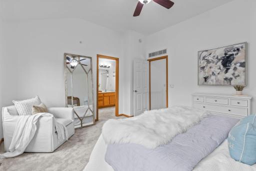 An alternate view of the primary bedroom showing access to the private ensuite bathroom and walk-in closet.