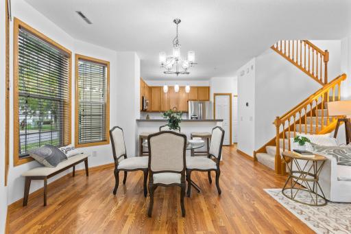 Just beyond, the dining area features a chandelier and large windows that fill the space with natural light.