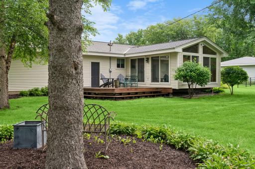 Beautifully landscaped backyard with a spacious deck and three-season porch.