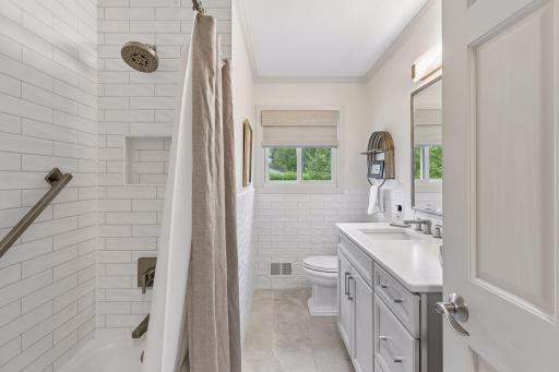 Beautifully remodeled main-level full bathroom featuring a subway tile tub and shower surround.