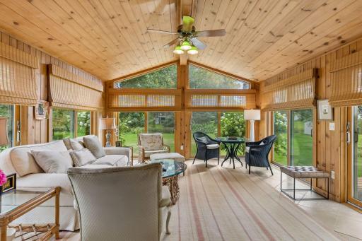 Inviting three-season porch featuring limestone flooring and a vaulted ceiling.
