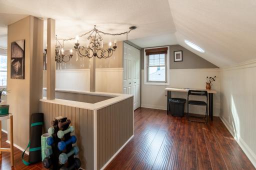 A solar tube seen above the desk provides great additional light without the use of lamps, and rich colored floors make this an inviting space.