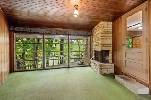 Side screen porch offers a peaceful spot to relax and enjoy the surrounding greenery.