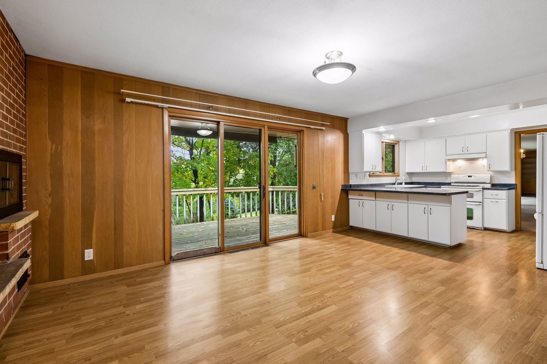 Kitchen opens to a cozy hearth room with a brick fireplace, space for casual dining or sitting area with direct access to the deck.