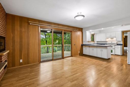Kitchen opens to a cozy hearth room with a brick fireplace, space for casual dining or sitting area with direct access to the deck.