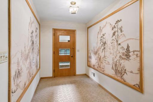 Distinctive front entry features two oversized framed wallpaper murals, adding character and vintage charm.