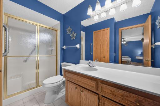Private primary ensuite bathroom with plenty of storage, grab rails, skylight, shower bench, gorgeous natural wood vanity with ample counter space.